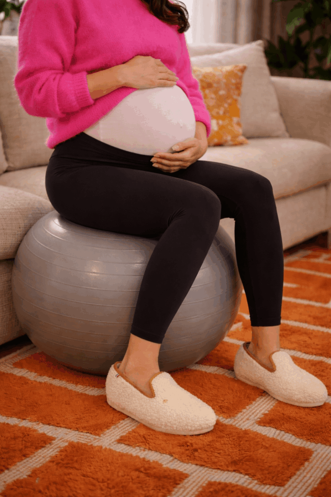 femme enceinte sur un ballon de gym avec des charentaises hellocotton, modèle Max